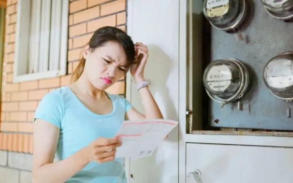 Mujer molesta viendo el recibo de la luz